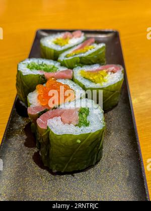 Rouleaux de sushi remplis de poisson et de légumes disposés sur une assiette. Banque D'Images