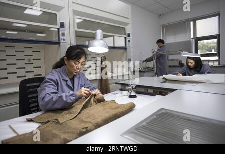 (171120) -- JINGZHOU, 20 novembre 2017 -- Un employé répare une relique culturelle en soie dans un centre de restauration à Jingzhou, dans la province du Hubei au centre de la Chine, 20 novembre 2017. Un nouveau site du centre de restauration des reliques culturelles, avec une superficie totale de construction de 9 300 mètres carrés, a été mis en service le 18 novembre. Le nouveau site dispose de plus de 40 équipements avancés et salles de restauration de reliques culturelles pour laque en bois, slip de bambou, produits textiles, cuir et etc. )(mcg) CHINA-HUBEI-JINGZHOU-CULTURAL RELIC RESTORATION (CN) XiongxQi PUBLICATIONxNOTxINxCHN Banque D'Images