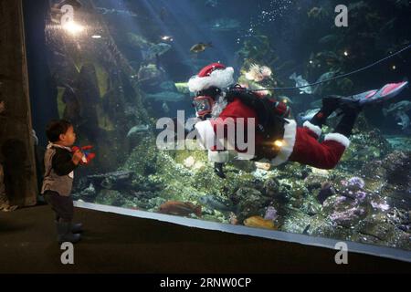 (171126) -- BEIJING, le 26 novembre 2017 -- Un plongeur habillé en Père Noël fait signe à un enfant à l'intérieur d'un aquarium pendant l'événement annuel Scuba Santa à l'Aquarium de Vancouver, Canada, le 23 novembre 2017. Le Scuba Santa est l'un des événements traditionnels pour célébrer la prochaine saison de Noël pour les visiteurs de l'Aquarium de Vancouver. ) XINHUA PHOTO CHOIX HEBDOMADAIRES LiangxSen PUBLICATIONxNOTxINxCHN Banque D'Images