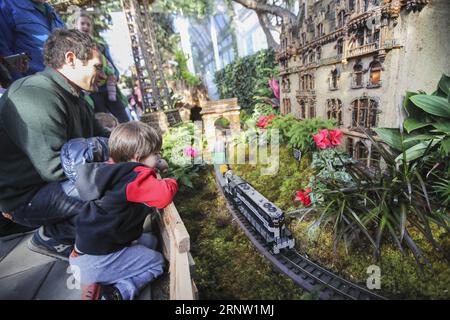 (171128) -- NEW YORK, 28 novembre 2017 -- les visiteurs observent un train miniature pendant le Holiday train Show au jardin botanique de New York, aux États-Unis, le 28 novembre 2017. Le Holiday train Show ouvre ses portes au public du 22 novembre 2017 au 15 janvier 2018, présentant environ 150 monuments New-yorkais faits de pièces d'usine et de trains miniatures à grande échelle. US-NEW YORK-TRAIN SHOW WangxYing PUBLICATIONxNOTxINxCHN Banque D'Images