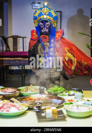 (171204) -- PÉKIN, 4 décembre 2017 -- un acteur joue le changement de visage de l'Opéra du Sichuan dans un restaurant hot pot à Chengdu, dans la province du Sichuan du sud-ouest de la Chine, le 24 novembre 2017. Populaire dans le Sichuan, Chongqing et Yunnan, l'opéra du Sichuan a environ 300 ans d'histoire. Il présente différents styles de chant des provinces orientales du Jiangsu et du Jiangxi, les mélodies de chant folklorique du nord-ouest du Shaanxi, et le chant dans le dialecte du Sichuan. Les trains à grande vitesse reliant Xi an, capitale de la province du Shaanxi, et Chengdu, capitale de la province du Sichuan, commenceront à fonctionner le 6 décembre, ont déclaré dimanche les autorités. Avec un Banque D'Images