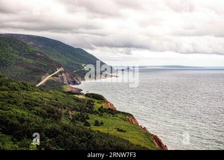 Le célèbre Cabot Trail au Cap-Breton, Nouvelle-Écosse, Canada sur l'océan Altantic par temps nuageux. Banque D'Images