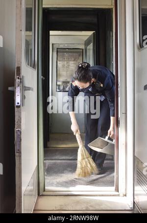 (171209) -- URUMQI, 9 déc. 2017 -- le préposé Subinuer Tayeer nettoie la poussière de sable sur le train n° 5809 reliant Kashgar et Hotan dans la région autonome ouygur du Xinjiang du nord-ouest de la Chine, 24 nov. 2017. La ligne de train de 485 km reliant deux grandes villes oasis de Kashgar et Hotan traverse certaines des zones les plus reculées du Xinjiang et a transformé la vie dans le désert depuis son lancement en 2011. C'est le premier et le seul chemin de fer de Hotan, via le chemin de fer la préfecture sous-développée est reliée au reste du réseau ferroviaire du pays, qui compte 22 000 km de lignes ferroviaires à grande vitesse. Transport infr. Médiocre Banque D'Images