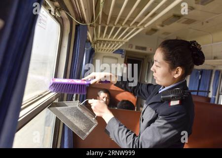 (171209) -- URUMQI, 9 déc. 2017 -- le préposé Subinuer Tayeer nettoie la poussière de sable sur le train n° 5809 reliant Kashgar et Hotan dans la région autonome ouygur du Xinjiang du nord-ouest de la Chine, 24 nov. 2017. La ligne de train de 485 km reliant deux grandes villes oasis de Kashgar et Hotan traverse certaines des zones les plus reculées du Xinjiang et a transformé la vie dans le désert depuis son lancement en 2011. C'est le premier et le seul chemin de fer de Hotan, via le chemin de fer la préfecture sous-développée est reliée au reste du réseau ferroviaire du pays, qui compte 22 000 km de lignes ferroviaires à grande vitesse. Transport infr. Médiocre Banque D'Images