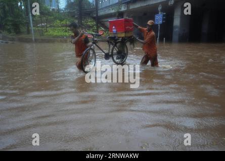 (171211) -- JAKARTA, 11 décembre 2017 -- des membres de l'Agence d'entretien des installations publiques (PPSU) tentent de transporter un vélo hors d'une rue gorgée d'eau à Jakarta, Indonésie, décembre 11. 2017. De fortes pluies de plusieurs heures ont laissé des rues gorgées d ' eau et provoqué des embouteillages dans certains quartiers de Jakarta.) (Zjl) INDONÉSIE-JAKARTA-PLUIE FORTE Zulkarnain PUBLICATIONxNOTxINxCHN Banque D'Images