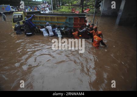 (171211) -- JAKARTA, 11 décembre 2017 -- des membres de l'Agence d'entretien des installations publiques (PPSU) et des habitants tentent de pousser un camion coincé dans une rue gorgée d'eau à Jakarta, Indonésie, décembre 11. 2017. De fortes pluies de plusieurs heures ont laissé des rues gorgées d ' eau et provoqué des embouteillages dans certains quartiers de Jakarta.) (Zjl) INDONÉSIE-JAKARTA-PLUIE FORTE Zulkarnain PUBLICATIONxNOTxINxCHN Banque D'Images