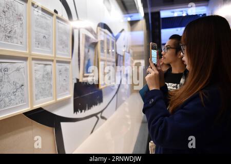 (171215) -- GUANGZHOU, 15 décembre 2017 -- Un visiteur prend des photos d'œuvres lors de la 1e exposition China animation & Comic Art à Guangzhou, dans la province du Guangdong du sud de la Chine, le 15 décembre 2017. L'exposition a ouvert ses portes vendredi. ) (Lb) CHINA-GUANGDONG-GUANGZHOU-ANIMATION & COMIC-EXHIBITION (CN) LiangxXu PUBLICATIONxNOTxINxCHN Banque D'Images