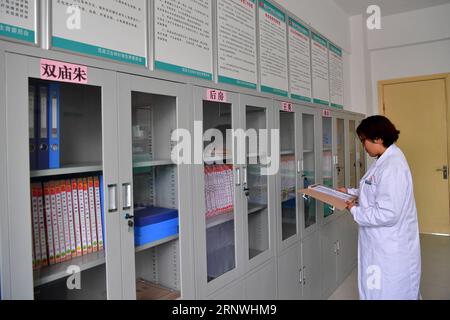 (171221) -- ZHENGZHOU, 21 décembre 2017 -- Un médecin vérifie les dossiers de santé des résidents dans une communauté de réinstallation du canton de Zhangzhuang, dans le comté de Fanxian, province du Henan, au centre de la Chine, 1 novembre 2017. À partir de la fin de 2014, le gouvernement provincial du Henan a organisé un projet pilote de réduction de la pauvreté visant à déplacer 14 villages le long du fleuve jaune de la zone de plaine inondable vers de nouvelles colonies, tout en encourageant les villageois réinstallés à développer l'industrie agricole et le tourisme pour augmenter leurs revenus. En août dernier, le projet a été officiellement approuvé par la Commission nationale de développement et de réforme de la Chine Banque D'Images