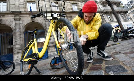 (171221) -- PARIS, 21 décembre 2017 -- le réparateur Yoann Andrieux répare une moto Ofo à Paris, France, le 20 décembre 2017. Deux semaines après son lancement ici, l un des programmes populaires de partage de vélos en Chine, Ofo, vise à devenir le leader sur le marché en pleine croissance alors que la ville s efforce de promouvoir le transport vert pour réduire les émissions. Les vélos jaunes lumineux de la marque peuvent être trouvés à la fois dans des monuments emblématiques et des coins de rue tranquilles autour de la ville, et gagnent rapidement en popularité parmi les habitants et les touristes.) FRANCE-PARIS-CHINE-PARTAGE DE VÉLOS-OFO CHENXYICHEN PUBLICATIONXNOTXINXCHN Banque D'Images