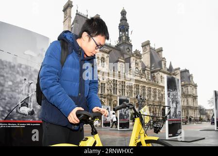 (171221) -- PARIS, le 21 décembre 2017 -- le touriste Zheng Shaoming ajuste le siège d'un vélo Ofo à Paris, France, le 20 décembre 2017. Deux semaines après son lancement ici, l un des programmes populaires de partage de vélos en Chine, Ofo, vise à devenir le leader sur le marché en pleine croissance alors que la ville s efforce de promouvoir le transport vert pour réduire les émissions. Les vélos jaunes lumineux de la marque peuvent être trouvés à la fois dans des monuments emblématiques et des coins de rue tranquilles autour de la ville, et gagnent rapidement en popularité parmi les habitants et les touristes.) FRANCE-PARIS-CHINE-PARTAGE DE VÉLOS-OFO CHENXYICHEN PUBLICATIONXNOTXINXCHN Banque D'Images