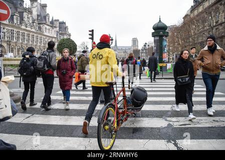 (171221) -- PARIS, 21 décembre 2017 -- le réparateur Yoann Andrieux traverse une rue pour entretenir un vélo Ofo à Paris, France, le 20 décembre 2017. Deux semaines après son lancement ici, l un des programmes populaires de partage de vélos en Chine, Ofo, vise à devenir le leader sur le marché en pleine croissance alors que la ville s efforce de promouvoir le transport vert pour réduire les émissions. Les vélos jaunes lumineux de la marque peuvent être trouvés à la fois dans des monuments emblématiques et des coins de rue tranquilles autour de la ville, et gagnent rapidement en popularité parmi les habitants et les touristes.) FRANCE-PARIS-CHINE-BIKE SHARING-OFO CHENXYICHEN PUBLIC Banque D'Images