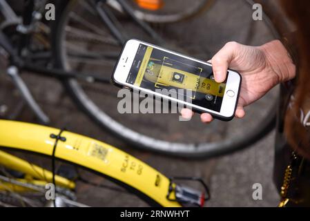 (171221) -- PARIS, 21 décembre 2017 -- Vigot Claire scanne un code QR pour déverrouiller un vélo Ofo à Paris, France, le 20 décembre 2017. Deux semaines après son lancement ici, l un des programmes populaires de partage de vélos en Chine, Ofo, vise à devenir le leader sur le marché en pleine croissance alors que la ville s efforce de promouvoir le transport vert pour réduire les émissions. Les vélos jaunes lumineux de la marque peuvent être trouvés à la fois dans des monuments emblématiques et des coins de rue tranquilles autour de la ville, et gagnent rapidement en popularité parmi les habitants et les touristes.) FRANCE-PARIS-CHINE-PARTAGE DE VÉLOS-OFO CHENXYICHEN PUBLICATIONXNOTXINXCHN Banque D'Images