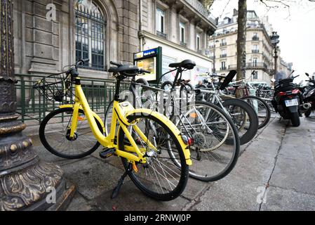 (171221) -- PARIS, 21 décembre 2017 -- la photo prise le 20 décembre 2017 montre un vélo Ofo (avant) à Paris, France. Deux semaines après son lancement ici, l un des programmes populaires de partage de vélos en Chine, Ofo, vise à devenir le leader sur le marché en pleine croissance alors que la ville s efforce de promouvoir le transport vert pour réduire les émissions. Les vélos jaunes lumineux de la marque peuvent être trouvés à la fois dans des monuments emblématiques et des coins de rue tranquilles autour de la ville, et gagnent rapidement en popularité parmi les habitants et les touristes.) FRANCE-PARIS-CHINE-PARTAGE DE VÉLOS-OFO CHENXYICHEN PUBLICATIONXNOTXINXCHN Banque D'Images