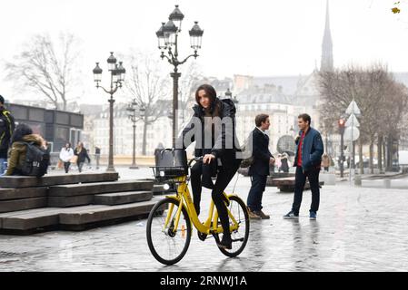 (171221) -- PARIS, 21 décembre 2017 -- Vigot Claire conduit un vélo Ofo à Paris, France, le 20 décembre 2017. Deux semaines après son lancement ici, l un des programmes populaires de partage de vélos en Chine, Ofo, vise à devenir le leader sur le marché en pleine croissance alors que la ville s efforce de promouvoir le transport vert pour réduire les émissions. Les vélos jaunes lumineux de la marque peuvent être trouvés à la fois dans des monuments emblématiques et des coins de rue tranquilles autour de la ville, et gagnent rapidement en popularité parmi les habitants et les touristes.) FRANCE-PARIS-CHINE-PARTAGE DE VÉLOS-OFO CHENXYICHEN PUBLICATIONXNOTXINXCHN Banque D'Images