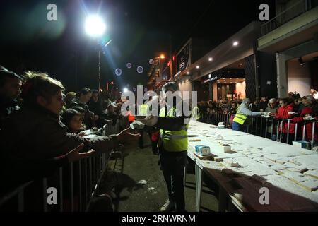 (171230) -- ATHÈNES, 30 décembre 2017 -- les boulangers grecs offrent de la vassilopita à des citoyens dans une rue d'Athènes, Grèce, le 30 décembre 2017. Les boulangers grecs ont envoyé leurs vœux pour un joyeux 2018 au monde samedi en faisant et en offrant gratuitement aux citoyens d'Athènes un Vassilopita de 2,5 tonnes , le gâteau spécial habituellement servi dans tous les foyers en Grèce après minuit le jour du nouvel an. GRÈCE-ATHÈNES-NOUVEL AN-GÂTEAU MariosxLolos PUBLICATIONxNOTxINxCHN Banque D'Images