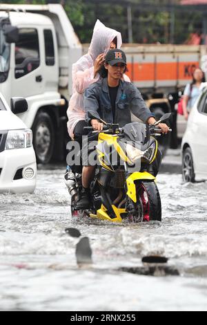 (180110) -- BANGKOK, 10 janvier 2018 -- des résidents roulent à moto le long d'une rue inondée à Bangkok, Thaïlande, 10 janvier 2018. Un certain nombre de rues de Bangkok ont été inondées après que de fortes pluies aient frappé la capitale mercredi matin. (Whw) THAÏLANDE-BANGKOK-INONDATIONS URBAINES RachenxSageamsak PUBLICATIONxNOTxINxCHN Banque D'Images