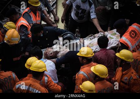 (180112) -- BEIJING, 12 janvier 2018 -- des sauveteurs transfèrent un homme blessé sur le site d'un bâtiment effondré à Mumbai, en Inde, le 31 août 2017.) XINHUA-PHOTOS DE L'ANNÉE 2017-MONDE BIXXIAOYANG PUBLICATIONXNOTXINXCHN Banque D'Images