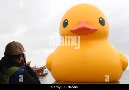 (180113) -- KUNMING, 13 janvier 2018 -- Un touriste prend des photos du canard en caoutchouc à Kunming, capitale de la province du Yunnan du sud-ouest de la Chine, le 13 janvier 2018. L'idée originale de l'artiste néerlandais Florentijn Hofman, le canard gonflable géant en caoutchouc, sera exposée jusqu'au 2 mars. ) (Lhy) CANARD EN CAOUTCHOUC CHINA-YUNNAN-KUNMING (CN) LinxYiguang PUBLICATIONxNOTxINxCHN Banque D'Images