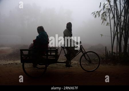 (180114) -- DHAKA, 14 janvier 2018 -- un homme monte un tire-pousse pendant un épais brouillard à Dhaka, la capitale du Bangladesh, aux premières heures du 14 janvier 2018.) (srb) BANGLADESH-DHAKA-FOG SalimxReza PUBLICATIONxNOTxINxCHN Banque D'Images