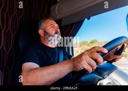 Conducteur du chariot conduisant les deux mains sur le volant en position d'alerte. Banque D'Images