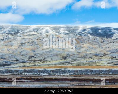 Conduite dans la neige et la glace sur la route panoramique Interstate 15 dans le sud-ouest du Montana à la fin octobre, avec les montagnes enneigées de Pioneer. Banque D'Images