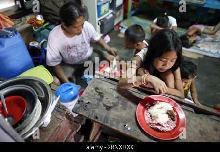 (180131) -- ALBAY, 31 janvier 2018 -- les enfants d'Ellen Padua prennent leur déjeuner dans le centre d'évacuation de la ville de Guinobatan à Albay, au centre des Philippines, le 31 janvier 2018. Ellen Padua fait partie des milliers de personnes déplacées par l éruption du volcan le plus actif du pays, le Mt. Mayon. Elle a évacué avec son mari Gabby et huit enfants, du village de Maninila, à environ quatre kilomètres du cratère du mont. Mayon. Actuellement, la famille est restée depuis près de trois semaines dans une école primaire de la ville de Guinobatan avec 19 autres familles de leur village. (lrz Banque D'Images