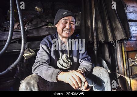 (180206) -- URUMQI, 6 février 2018 -- une photo prise le 19 janvier 2018 montre stoker Dai Yanjia se frottant les ongles avec une pierre dans la zone de la mine de charbon de Sandaoling à Hami, dans la région autonome ouygur du Xinjiang du nord-ouest de la Chine. Il y avait au total plus de 30 locomotives à vapeur en circulation à Sandaoling, une zone clé de la mine de charbon dans le nord-ouest du Xinjiang de la Chine, à la fin des années 1990, mais ce nombre a diminué à seulement 11 aujourd'hui. Responsables de l'exploitation et du transport du charbon dans la région, les locomotives à vapeur ont été dépassées en raison du développement de la science et de la technologie, et seront démantelées une fois en panne depuis pas de pair Banque D'Images