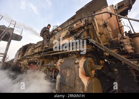 (180206) -- URUMQI, 6 février 2018 -- une photo prise le 19 janvier 2018 montre le conducteur Cheng Zhongyun vérifiant une locomotive à vapeur dans la zone de la mine de charbon de Sandaoling à Hami, dans la région autonome ouygur du Xinjiang du nord-ouest de la Chine. Il y avait au total plus de 30 locomotives à vapeur en circulation à Sandaoling, une zone clé de la mine de charbon dans le nord-ouest du Xinjiang de la Chine, à la fin des années 1990, mais ce nombre a diminué à seulement 11 aujourd'hui. Responsables de l'exploitation et du transport du charbon dans la région, les locomotives à vapeur ont été dépassées en raison du développement de la science et de la technologie, et seront démantelées une fois en panne depuis pas de pa Banque D'Images