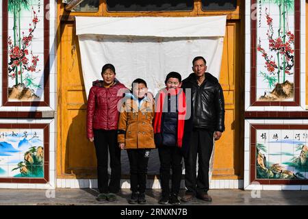 (180206) -- KANGLE, 6 février 2018 -- Sun Jianjun (2e R) et son père Sun Shihai, sa mère Wu Pingxia, son frère cadet Sun Jianqiang posent pour des photos à la maison dans le village de Xinzhuang, canton de Basong, comté de Kangle dans la province du Gansu du nord-ouest de la Chine, le 3 février 2018. La fête du printemps, ou nouvel an lunaire chinois, tombe le 16 février de cette année. Des centaines de millions de Chinois retourneront dans leur ville natale pour des réunions de famille. Sun Jianjun, 14 ans, et ses 15 camarades de classe font partie de ces voyageurs désireux de rentrer chez eux. Le 1 février, le premier jour de la ruée de voyage du Festival du printemps 2018, ils ont marché sur un Banque D'Images