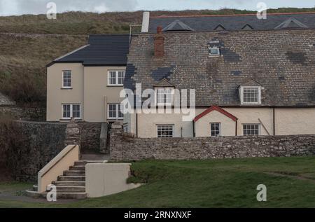 Marches menant aux cottages en bord de mer un jour d'hiver de surcaste Banque D'Images