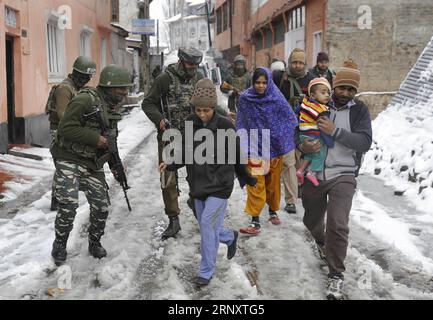 (180212) -- SRINAGAR, 12 février 2018 -- des troupes paramilitaires indiennes escortent des gens d'un site de fusillades vers un endroit plus sûr dans la ville de Srinagar, la capitale estivale du Cachemire contrôlé par l'Inde, 12 février 2018. Une troupe paramilitaire appartenant à la Central Reserve police Force (CRPF) a été blessée lundi dans une violente fusillade avec des militants dans le Cachemire contrôlé par l'Inde, a déclaré la police. La fusillade a éclaté à Karan Nagar, localité de la ville de Srinagar.) (zy) KASHMIR-SRINAGAR-GUNFIGHT JavedxDar PUBLICATIONxNOTxINxCHN Banque D'Images