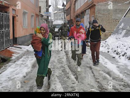 (180212) -- SRINAGAR, 12 février 2018 -- des troupes paramilitaires indiennes escortent des gens d'un site de fusillades vers un endroit plus sûr dans la ville de Srinagar, la capitale estivale du Cachemire contrôlé par l'Inde, 12 février 2018. Une troupe paramilitaire appartenant à la Central Reserve police Force (CRPF) a été blessée lundi dans une violente fusillade avec des militants dans le Cachemire contrôlé par l'Inde, a déclaré la police. La fusillade a éclaté à Karan Nagar, localité de la ville de Srinagar.) (zy) KASHMIR-SRINAGAR-GUNFIGHT JavedxDar PUBLICATIONxNOTxINxCHN Banque D'Images