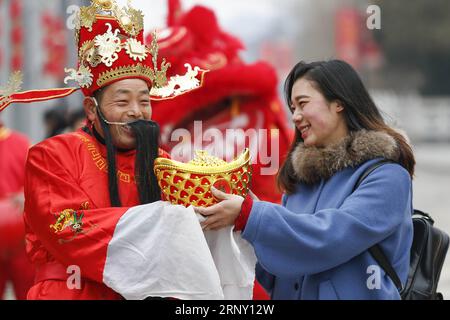 (180220) -- TAIZHOU, 20 février 2018 -- un homme habillé comme le Dieu de la richesse envoie présent à un touriste à Taizhou, province de Jiangsu dans l'est de la Chine, le 20 février 2018, le cinquième jour du nouvel an lunaire chinois qui est censé être l'anniversaire du Dieu de la richesse. Le Dieu de la richesse est censé apporter la fortune aux gens. ) (Wyo) CHINE-LUNAR NOUVEL AN-DIEU DE LA RICHESSE (CN) TangxDehong PUBLICATIONxNOTxINxCHN Banque D'Images