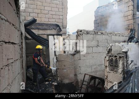 (180228) -- QUEZON CITY, 28 février 2018 -- Un pompier éteint le feu restant après un incendie dans un bidonville de Quezon City, Philippines, le 28 février 2018. Plus de 100 bidonvilles ont été rasées dans l'incendie, laissant 350 familles sans abri.) rh) LE FEU DE VILLE PHILIPPINES-QUEZON ROUELLExUMALI PUBLICATIONxNOTxINxCHN Banque D'Images