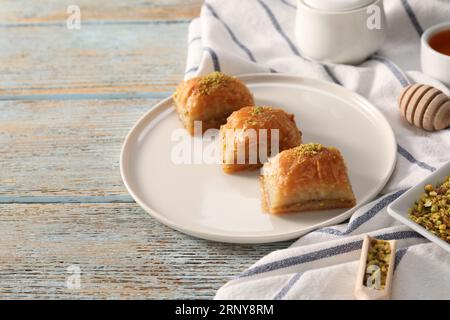 Délicieux baklava sucré avec des pistaches sur une table en bois bleu clair, espace pour le texte Banque D'Images