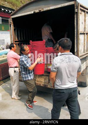 (180317) -- PÉKIN, 17 mars 2018 () -- une photo de fichier non datée montre long Xianwen (2e L) transportant des poubelles dans le village de Niujiaoshan, dans le comté de Guzhang, province du Hunan, au centre de la Chine. Long Xianwen du groupe ethnique Miao, vient du village de Niujiaoshan dans le comté de Guzhang, province du Hunan en Chine centrale. En tant que secrétaire de village de la branche du Parti communiste chinois, long conduit les villageois à développer des affaires locales en lançant des plantations de thé et du tourisme rural. Le village, situé dans des zones montagneuses reculées, était autrefois un endroit frappé de pauvreté où le revenu net annuel par habitant il y a dix ans W Banque D'Images