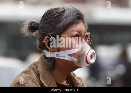 (180328) -- PÉKIN, le 28 mars 2018 -- Une femme roule contre la poussière et le sable flottants à Pékin, capitale de la Chine, le 28 mars 2018. La poussière flottante a frappé Pékin mercredi. )(mcg) CHINA-BEIJING-WEATHER-DUST (CN) JuxHuanzong PUBLICATIONxNOTxINxCHN Banque D'Images