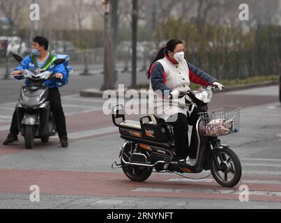 (180328) -- PÉKIN, le 28 mars 2018 -- des citoyens roulent contre la poussière et le sable flottants à Pékin, capitale de la Chine, le 28 mars 2018. La poussière flottante a frappé Pékin mercredi. )(mcg) CHINA-BEIJING-WEATHER-DUST (CN) ZhangxChenlin PUBLICATIONxNOTxINxCHN Banque D'Images