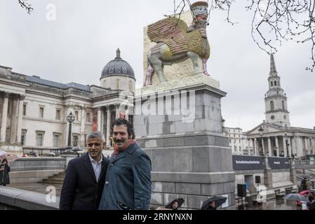 (180328) -- LONDRES, le 28 mars 2018 -- Michael Rakowitz (à droite) pose avec Sadiq Khan, maire de Londres, après que son nouveau travail The invisible Enemy should not exist a été dévoilé sur le quatrième Plinth à Trafalgar Square, en Grande-Bretagne, le 28 mars 2018. La sculpture faite à partir de 10 500 boîtes de sirop de dattes irakiennes vides, est une réplique de Lamassu, un taureau ailé et divinité protectrice, qui se tenait à l'entrée de la porte Nergal de Ninive de 700 av. J.-C. jusqu'à ce qu'elle soit détruite par l'Etat islamique en 2015. Il s'agit du 12e travail à apparaître sur le quatrième Plinthe depuis le début du programme de mise en service en 1998, et il sera sur la plinthe Banque D'Images