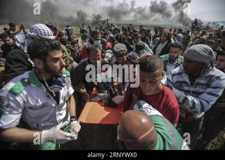 (180406) -- GAZA, 6 avril 2018 -- des manifestants palestiniens portent un homme blessé lors d'affrontements avec les troupes israéliennes à la frontière Gaza-Israël, à l'est de la ville de Gaza, le 6 avril 2018. Huit Palestiniens ont été tués et 1 070 autres blessés vendredi au cours d'une journée d'affrontements sanglants entre des centaines de manifestants palestiniens et des soldats israéliens à la frontière entre Israël et la bande de Gaza, ont déclaré les médecins. MIDEAST-GAZA-AFFRONTEMENTS WissamxNassar PUBLICATIONxNOTxINxCHN Banque D'Images