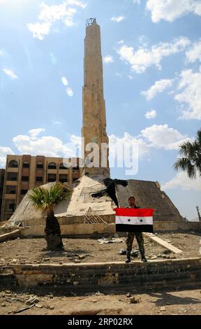 (180414) -- DOUMA, 14 avril 2018 -- Un policier syrien tient un drapeau national syrien dans le district de Douma, à l'est de Damas, en Syrie, le 14 avril 2018. La police militaire russe et les forces de police syriennes ont commencé à se déployer dans toute la Douma conformément à l’accord conclu le 8 avril, en vertu duquel les institutions officielles syriennes retourneront à Douma.) (Zjl) SYRIE-DAMAS-DOUMA-RUSSIE-DÉPLOIEMENT AmmarxSafarjalani PUBLICATIONxNOTxINxCHN Banque D'Images