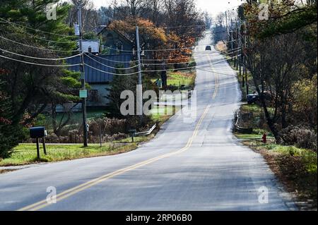 Une voiture grimpe sur une route vallonnée, en haut d'une colline sur Crosstown Road à Berlin, Vermont, Nouvelle-Angleterre, États-Unis. Banque D'Images