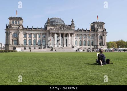 (180423) -- BERLIN, le 23 avril 2018 -- Un homme lit un livre devant le Reichstag à Berlin, Allemagne, le 19 avril 2018. L'Organisation des Nations Unies pour l'éducation, la science et la culture (UNESCO) a désigné le 23 avril Journée mondiale du livre en 1995 pour rendre hommage aux livres et aux auteurs et encourager les gens à découvrir le plaisir de la lecture. )(zcc) ALLEMAGNE-BERLIN-JOURNÉE MONDIALE DU LIVRE ShanxYuqi PUBLICATIONxNOTxINxCHN Banque D'Images