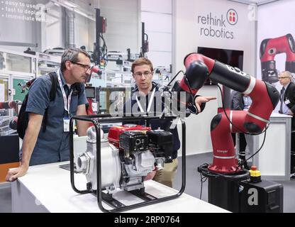 (180423) -- HANOVRE (ALLEMAGNE), le 23 avril 2018 -- un membre du personnel du stand de Rethink Robotics présente un produit à un visiteur lors de la Foire de Hanovre 2018 à Hanovre, en Allemagne, le 23 avril 2018. Hanovre Fair, le plus grand salon industriel mondial, a ouvert ses portes dimanche, alors que la chancelière allemande Angela Merkel soulignait l importance du libre-échange. ALLEMAGNE-HANOVRE-HANOVRE FOIRE ShanxYuqi PUBLICATIONxNOTxINxCHN Banque D'Images