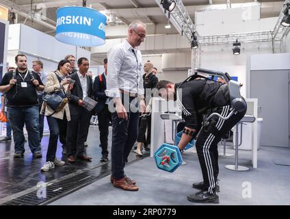 (180423) -- HANOVRE (ALLEMAGNE), le 23 avril 2018 -- Un visiteur découvre l'exosquelette sur le stand de German Bionic Systems lors de la Foire de Hanovre 2018 à Hanovre, Allemagne, le 23 avril 2018. Hanovre Fair, le plus grand salon industriel mondial, a ouvert ses portes dimanche, alors que la chancelière allemande Angela Merkel soulignait l importance du libre-échange. ALLEMAGNE-HANOVRE-HANOVRE FOIRE ShanxYuqi PUBLICATIONxNOTxINxCHN Banque D'Images