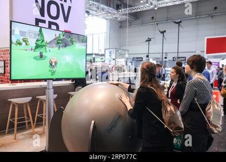 (180423) -- HANOVRE (ALLEMAGNE), le 23 avril 2018 -- les visiteurs font l'expérience d'un jeu de physioball sur le stand de Sisyfox lors de la Foire de Hanovre 2018 à Hanovre, Allemagne, le 23 avril 2018. Hanovre Fair, le plus grand salon industriel mondial, a ouvert ses portes dimanche, alors que la chancelière allemande Angela Merkel soulignait l importance du libre-échange. ALLEMAGNE-HANOVRE-HANOVRE FOIRE ShanxYuqi PUBLICATIONxNOTxINxCHN Banque D'Images