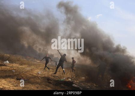 (180427) -- GAZA, 27 avril 2018 -- Un manifestant palestinien utilise une fronde pour lancer des pierres sur les troupes israéliennes lors d'affrontements à la frontière Gaza-Israël, à l'est de la ville de Khan Younis, au Sud de la bande de Gaza, le 27 avril 2018.) (hy) MIDEAST-GAZA-AFFRONTEMENTS KhaledxOmar PUBLICATIONxNOTxINxCHN Banque D'Images