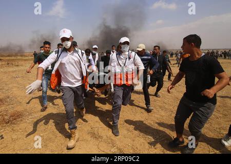 (180427) -- GAZA, 27 avril 2018 -- des médecins palestiniens transportent un blessé lors d'affrontements avec les troupes israéliennes à la frontière Gaza-Israël, à l'est de la ville de Khan Younis, au Sud de la bande de Gaza, le 27 avril 2018.) (hy) MIDEAST-GAZA-AFFRONTEMENTS KhaledxOmar PUBLICATIONxNOTxINxCHN Banque D'Images