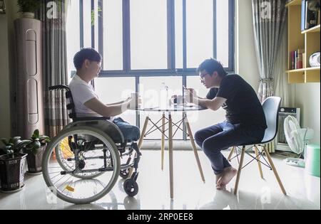 (180510) -- BEICHUAN, le 10 mai 2018 -- Zheng Haiyang (L), un survivant qui a perdu ses jambes dans le tremblement de terre de magnitude 8,0 de Wenchuan en 2008, discute avec son ami chez lui dans le nouveau comté de Beichuan, dans la province du Sichuan, au sud-ouest de la Chine, le 8 mai 2018. Il y a dix ans, Zheng, alors élève de 17 ans à l’école secondaire de Beichuan, a été extirpé 22 heures après avoir été pris au piège dans les décombres du bâtiment de l’école dans le comté de Beichuan. Beichuan a été l'une des régions les plus touchées lorsque le séisme catastrophique a frappé le comté de Wenchuan le 12 mai 2008. Zheng était un survivant du tremblement de terre qui a laissé plus de Banque D'Images