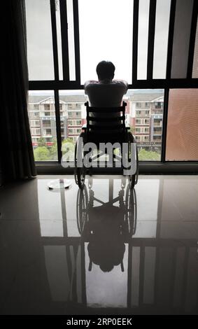 (180510) -- BEICHUAN, 10 mai 2018 -- Zheng Haiyang, survivant qui a perdu ses jambes dans le tremblement de terre de magnitude 8,0 de Wenchuan en 2008, regarde par la fenêtre dans le nouveau comté de Beichuan, dans la province du Sichuan, au sud-ouest de la Chine, le 8 mai 2018. Il y a dix ans, Zheng, alors élève de 17 ans à l’école secondaire de Beichuan, a été extirpé 22 heures après avoir été pris au piège dans les décombres du bâtiment de l’école dans le comté de Beichuan. Beichuan a été l'une des régions les plus touchées lorsque le séisme catastrophique a frappé le comté de Wenchuan le 12 mai 2008. Zheng était un survivant du tremblement de terre qui a laissé plus de 80 Banque D'Images